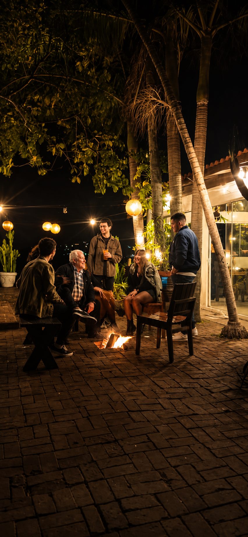 Grupo reunido ao redor da fogueira à noite, no pátio da Lagoa Nômade